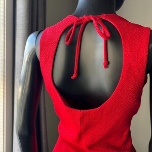 May include: A red sleeveless dress with a keyhole back and a tie at the back of the neck.