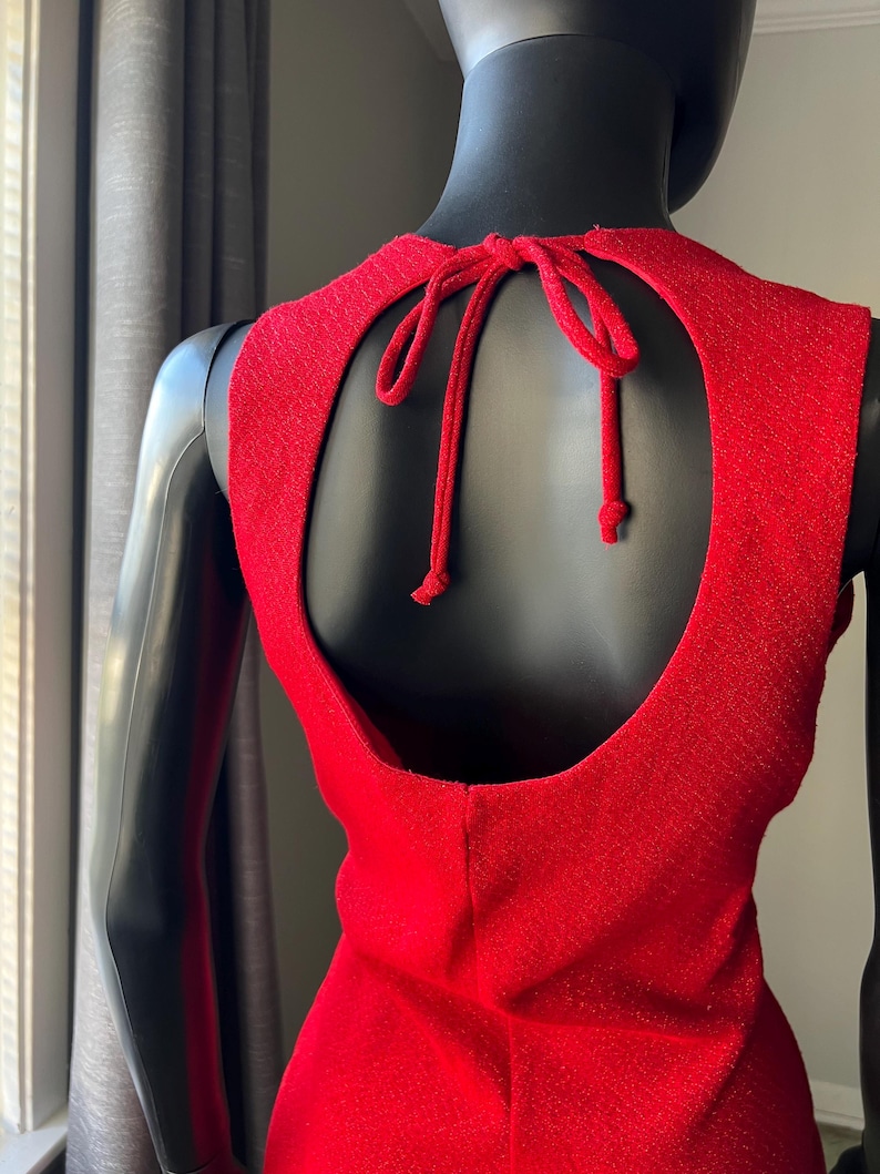 May include: A red sleeveless dress with a keyhole back and a tie at the back of the neck.