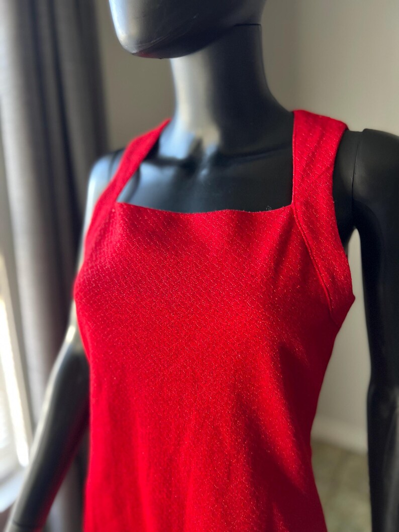 May include: A sleeveless red dress with a square neckline and a textured fabric.