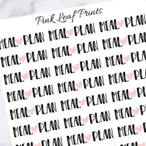 May include: A sheet of stickers with the text "MEAL PLAN" repeated multiple times. Each sticker has a small pink heart.