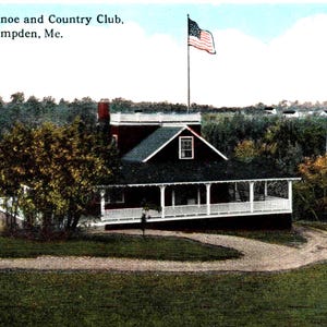 Puede incluir: Postal vintage del Conduskeag Canoe and Country Club en Hampden, Maine. La imagen muestra un edificio con porche, rodeado de árboles y un camino sinuoso. Una bandera estadounidense ondea al fondo.
