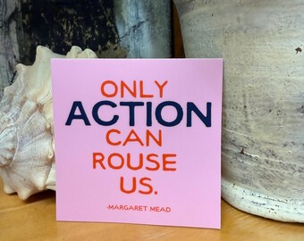 May include: A pink square card with the quote "ONLY ACTION CAN ROUSE US." in navy and red lettering, attributed to Margaret Mead. The card is displayed on a wooden surface, with a seashell and potted plant in the background.