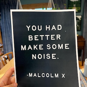May include: Black and white print with the quote "You had better make some noise." attributed to Malcolm X.