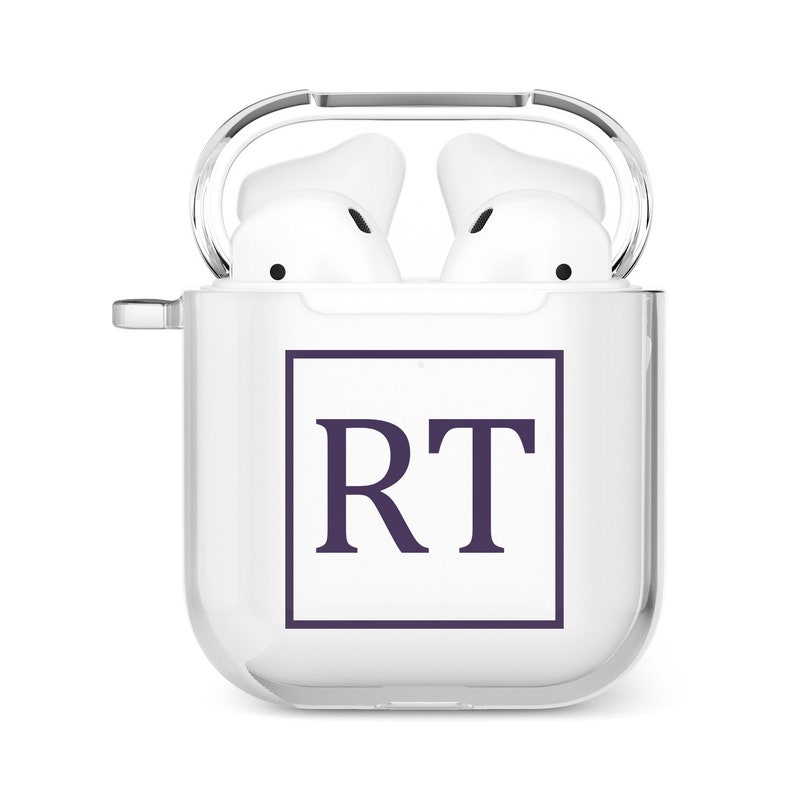 Puede incluir: Estuche blanco para auriculares inal&aacute;mbricos con tapa transparente. El estuche tiene un dise&ntilde;o cuadrado con las iniciales "RT" en color morado oscuro.