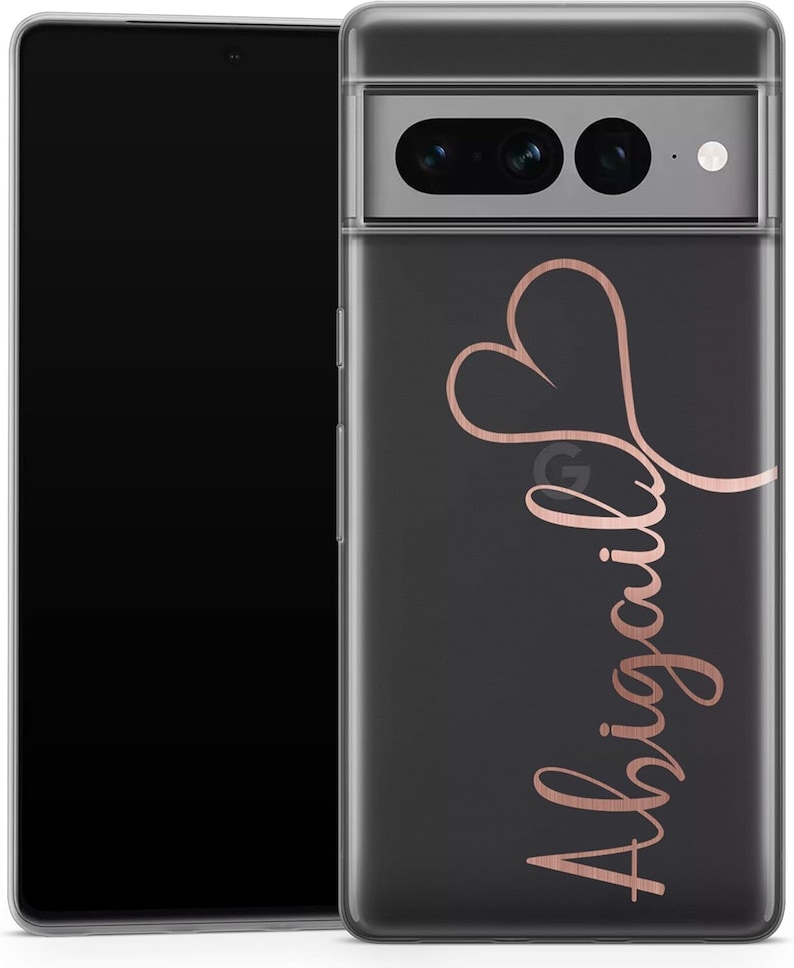 May include: A clear phone case with a black background and a rose gold heart design and the name "Abigail" in cursive script. The phone case is on a black smartphone.