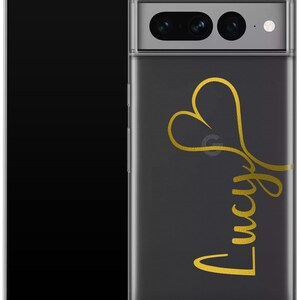 May include: A clear phone case with a black background and a gold heart design. The name "Lucy" is written in gold script below the heart. The phone case is shown with a black smartphone.
