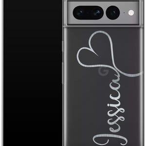 May include: A clear phone case with a black background and the name "Jessica" in a cursive font. A silver heart design is above the name. The phone case is on a black smartphone.