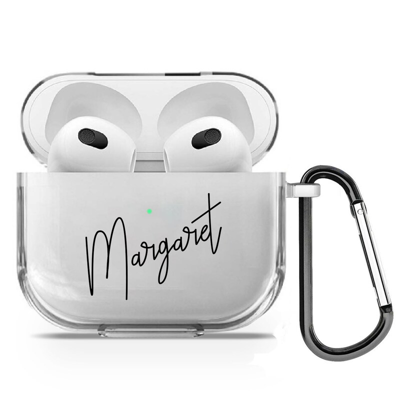 Puede incluir: Una funda transparente de pl&aacute;stico para auriculares inal&aacute;mbricos con un mosquet&oacute;n negro. La funda tiene el nombre "Margaret" escrito en cursiva negra.
