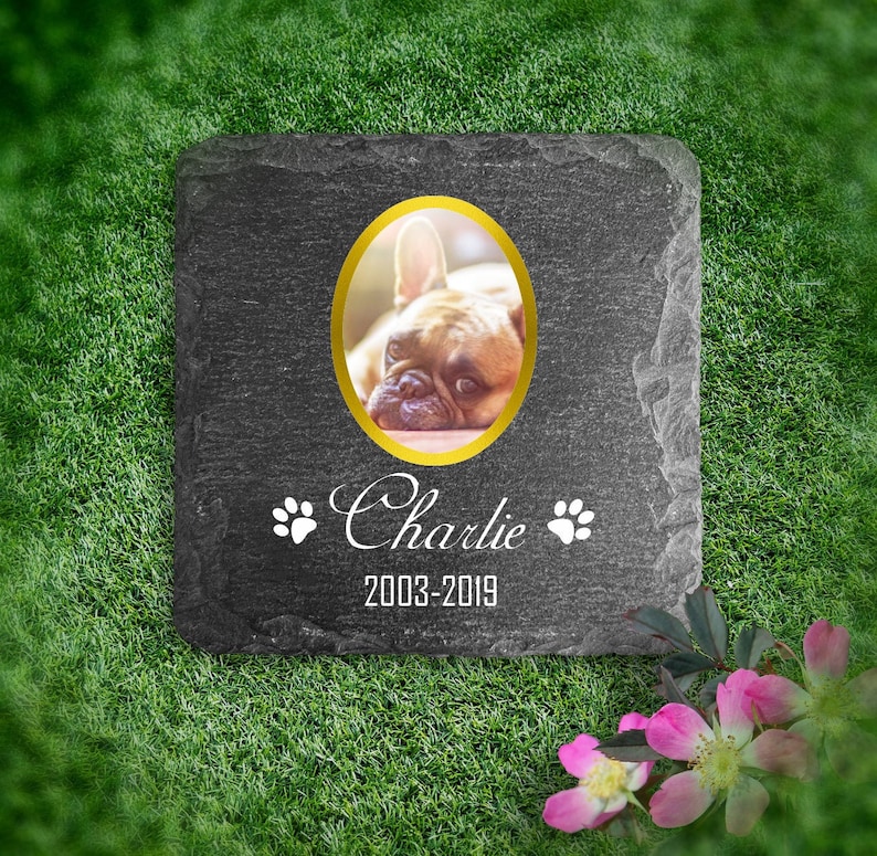 Puede incluir: Un memorial de mascota de pizarra gris con un marco ovalado dorado que contiene una foto de un Bulldog Franc&eacute;s. El memorial tiene el nombre "Charlie" y las fechas "2003-2019" inscritas en &eacute;l.