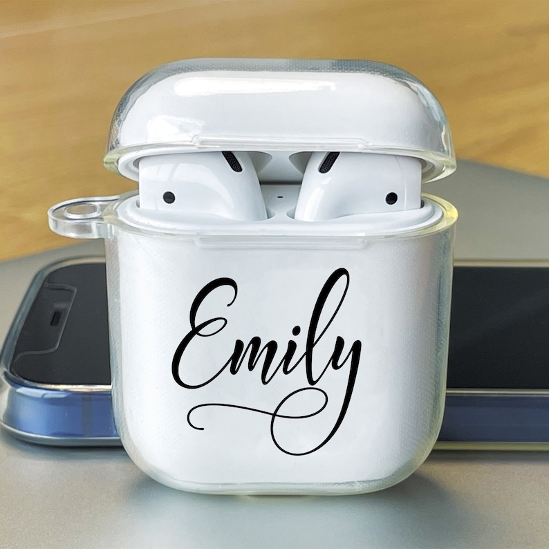 Puede incluir: Una funda de pl&aacute;stico transparente blanca para auriculares inal&aacute;mbricos con el nombre "Emily" impreso en la parte delantera.
