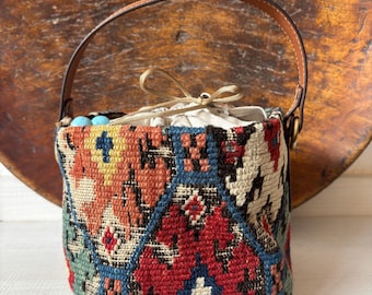 Vintage kilim bag, leather bucket bag with shoulder straps. Tobacco pouch closure with decorative beads. Measures 20x17 cm