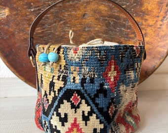 Vintage kilim bag, leather bucket bag with shoulder straps. Tobacco pouch closure with decorative beads. Measures 20x17 cm
