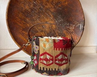 Vintage kilim bag, leather bucket bag with shoulder straps. Tobacco pouch closure with decorative beads. Measures 20x17 cm