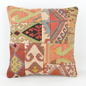 Könnte beinhalten: Quadratisches Patchwork-Kissen mit verschiedenen geometrischen Mustern in Rot-, Grün-, Beige- und Blautönen. Das Kissen hat ein strukturiertes Aussehen und einen neutralen Hintergrund.