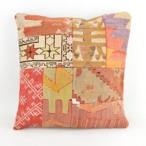 Könnte beinhalten: Quadratisches Patchwork-Kissen mit verschiedenen geometrischen Mustern in Rot-, Orange-, Gelb-, Beige- und Lilatönen. Das Kissen hat ein strukturiertes, gewebtes Aussehen und ist wahrscheinlich aus Stoff.