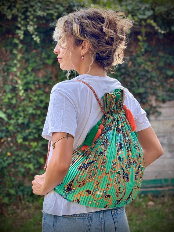 Bolso plisado estilo Issey Miyake de diseño ikat. Mochila ikat de 45x55 cm con forro de raso y cordones con abalorios de cristal y pompones