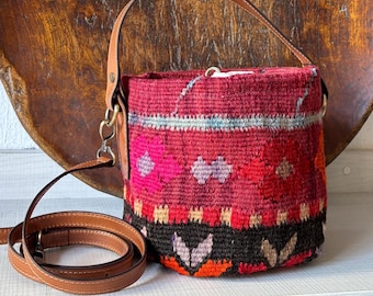 Vintage kilim bag, leather bucket bag with shoulder straps. Tobacco pouch closure with decorative beads. Measures 20x17 cm