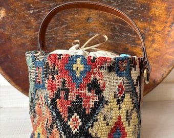 Vintage kilim bag, leather bucket bag with shoulder straps. Tobacco pouch closure with decorative beads. Measures 20x17 cm
