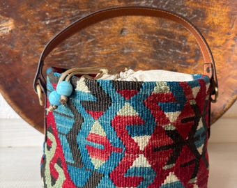 Vintage kilim bag, leather bucket bag with shoulder straps. Tobacco pouch closure with decorative beads. Measures 20x17 cm