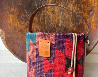 Vintage kilim bag, leather bucket bag with shoulder straps. Tobacco pouch closure with decorative beads. Measures 20x17 cm