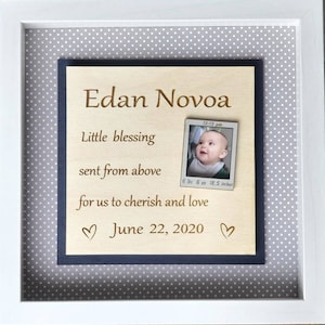 May include: A wooden plaque with a photo of a baby and the text "Edan Novoa", "Little blessing sent from above", "for us to cherish and love", and "June 22, 2020". The photo shows a baby with a white bib and the text "12:13 pm", "6 lbs 6 oz 18.5 inches".