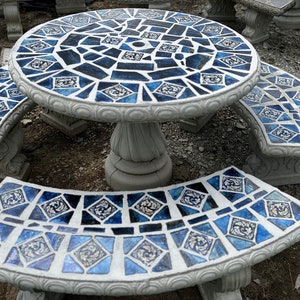 May include: A blue and white mosaic tile outdoor table set with a round table and three curved benches.