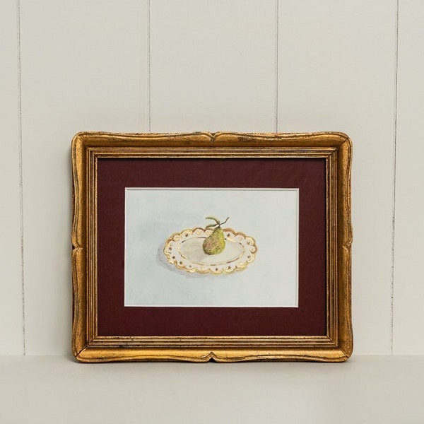 Pear on a plate still life with red linen mount framed in an antique gold wood frame, with gold leaf details