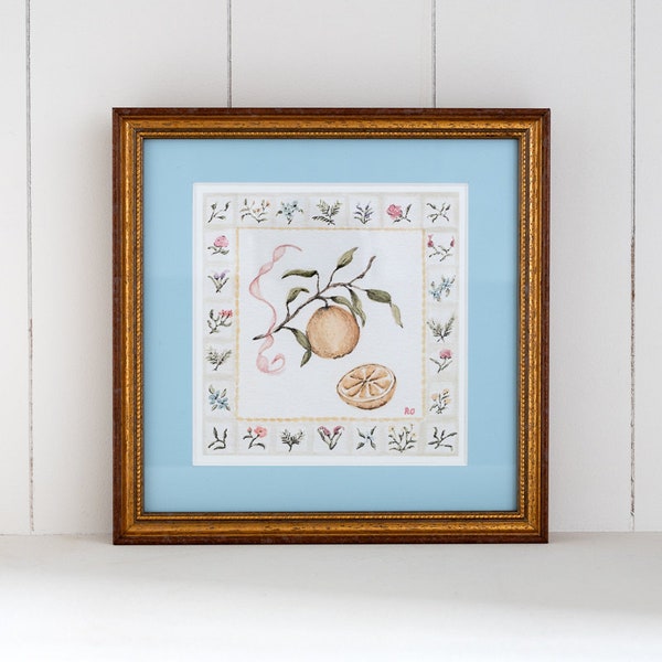 A small square fruit and flower print, hand framed in a gold wood frame with a blue mount, inspired by the life and kitchen in provence