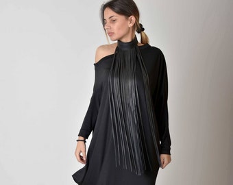 May include: A black asymmetrical dress with long sleeves and a black leather fringe necklace.