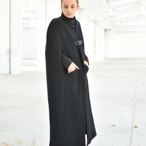 May include: A long black cape with a buckle closure and pockets. The cape is made of a thick, warm fabric and is perfect for cold weather.