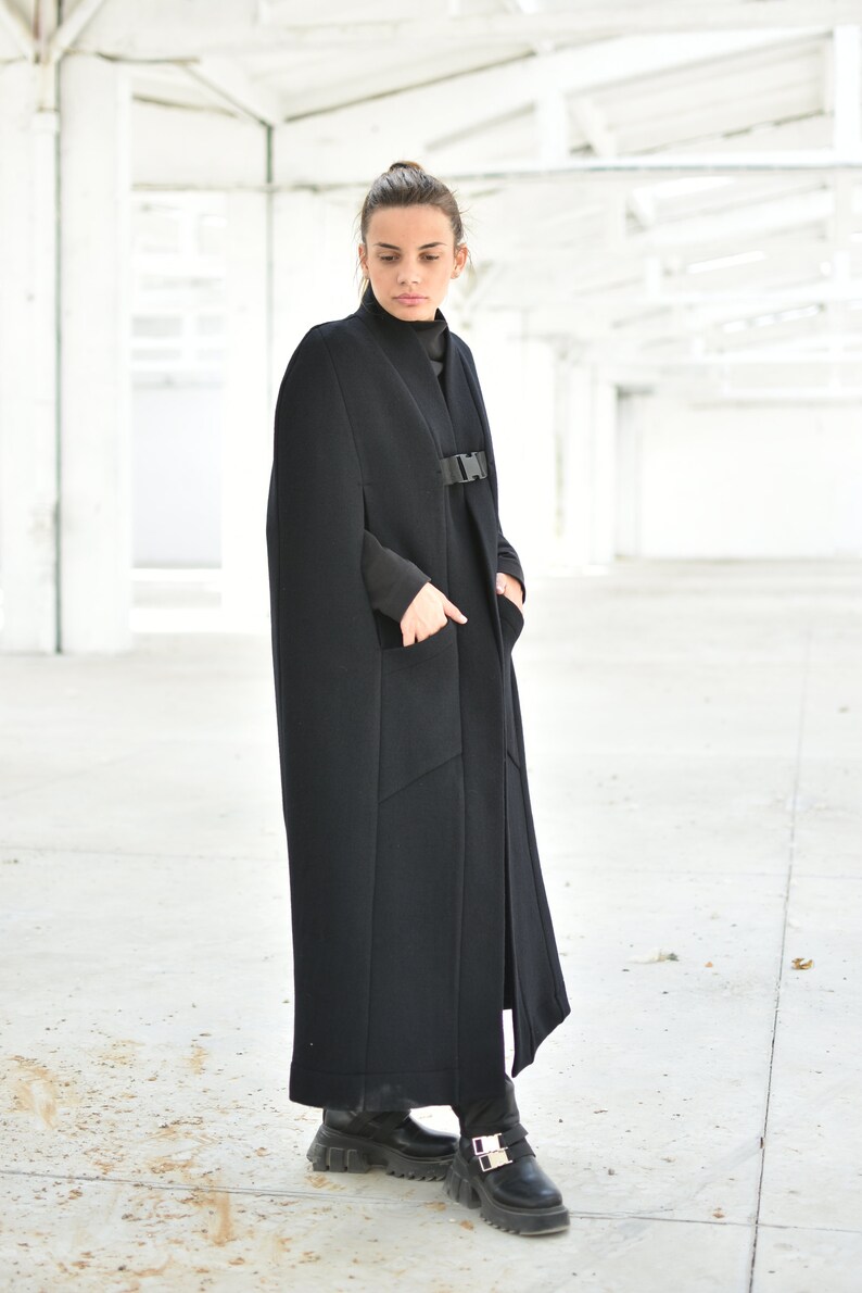 May include: A long black cape with a buckle closure and pockets. The cape is made of a thick, warm fabric and is perfect for cold weather.