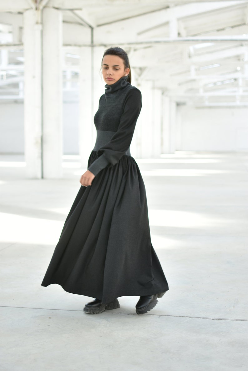 May include: A black long-sleeved dress with a high neck and a gathered skirt. The dress is made of a soft, comfortable fabric and has a relaxed fit.