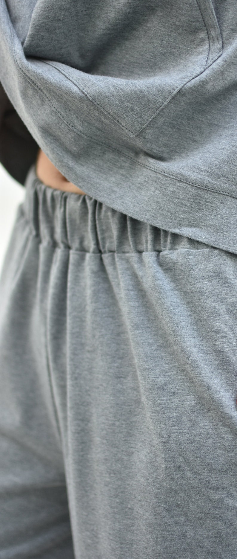 May include: Gray sweatpants with an elastic waistband.