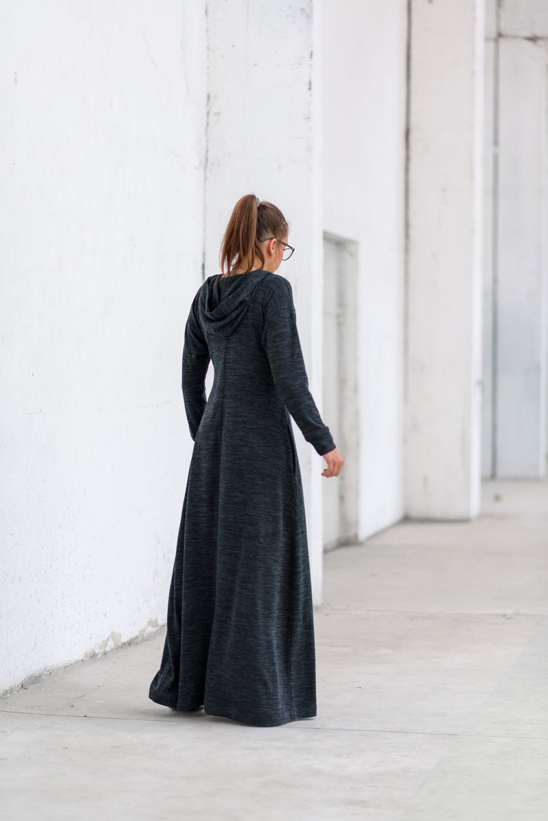 May include: A long, dark gray hooded dress with a loose fit and a flowing skirt. The dress is made of a soft, comfortable fabric.