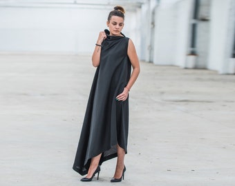 May include: A black sleeveless maxi dress with a high, cowl neck and a flowing, asymmetrical hemline.