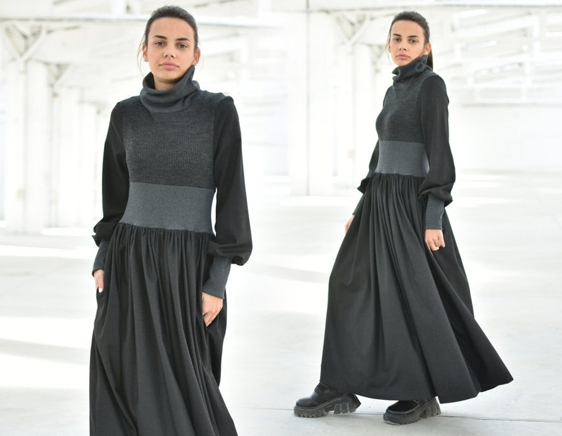 May include: A long black and grey dress with a turtleneck and long sleeves. The dress has a fitted bodice and a flowing skirt.