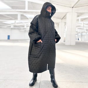 Piumino lungo nero, cappotto trapuntato con cappuccio, giacca invernale oversize con collo alto da donna, cappotto d'avanguardia, giacca cyberpunk futuristica