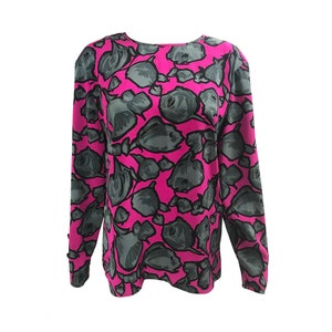 May include: A long-sleeved pink blouse with a grey floral print.