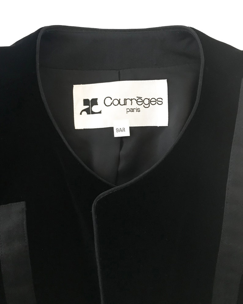 May include: Black velvet vest with a black satin trim and a white label that reads "Courr&egrave;ges Paris 9AR".