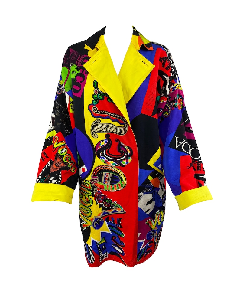 May include: A long-sleeved, multi-colored coat with a geometric pattern. The coat has a yellow collar and cuffs, and the pattern includes various colors, including red, blue, black, and yellow. The coat is made of a lightweight fabric and has a relaxed fit.