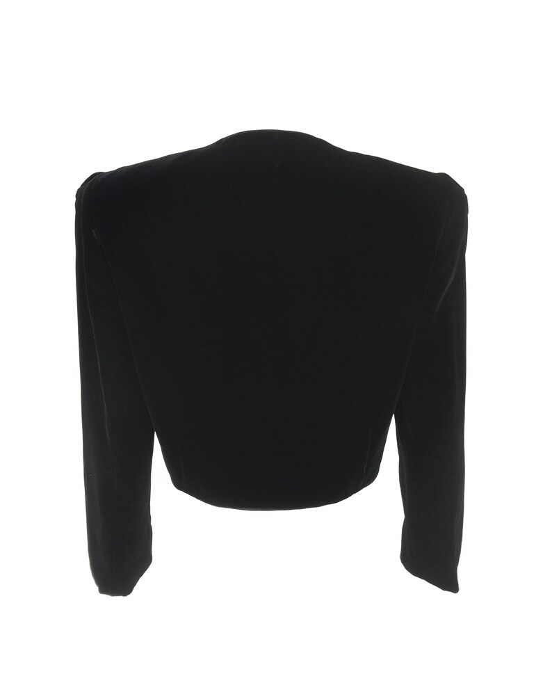 May include: A black velvet cropped jacket with long sleeves and a V-neck.