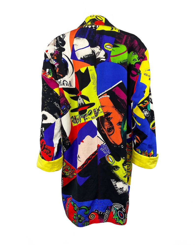May include: A long black jacket with a colorful collage print featuring various images, including faces, text, and abstract designs. The jacket has yellow cuffs and a collar.