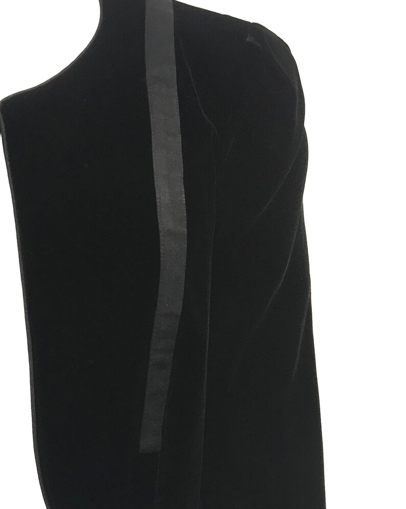 May include: Black velvet dress with a black satin stripe down the side.