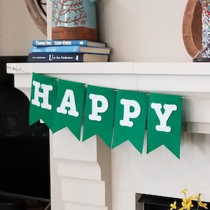 May include: A green banner with white letters that reads "HAPPY SUMMER" is hung above a white fireplace mantel.