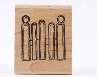 May include: Wooden rubber stamp with a black ink design of a picket fence.
