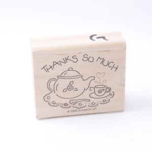May include: A wooden rubber stamp with the text "THANKS SO MUCH" and a black and white illustration of a teapot, teacup, and saucer on a doily. The stamp is made by Stampin' Up! and is copyrighted 1996.