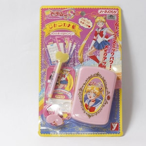 May include: A Sailor Moon S themed stationery set in original yellow packaging. The set includes a pink rectangular case with a character illustration, a heart-topped pen, and small cards. The packaging features Japanese text and graphics of the character.