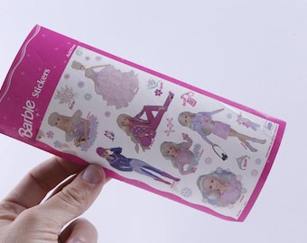 May include: A package of Barbie stickers featuring various Barbie dolls in different outfits. The stickers are on a white background with a pink border and the word "Barbie" in pink. The stickers are acid-free.