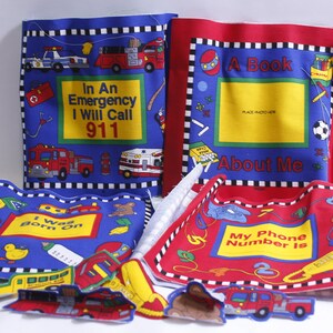 May include: A set of four fabric-covered books for children. The books are blue and red with black and white trim. The covers feature illustrations of a police car, fire truck, ambulance, and a teddy bear. The text on the covers reads "In An Emergency I Will Call 911", "A Book About Me", "I Was Born On", and "My Phone Number Is".