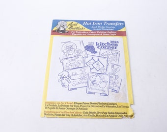 May include: A pack of iron-on transfers for crafts. The pack features a blue and white illustration of a kitchen scene with the text "3824 kitchen corner". The pack is yellow with a red and white border.